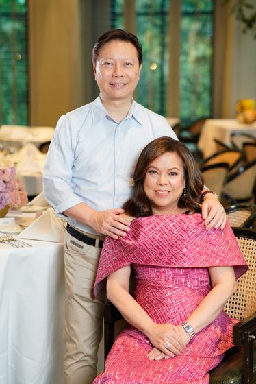 A couple at a birthday dinner, arms around each other