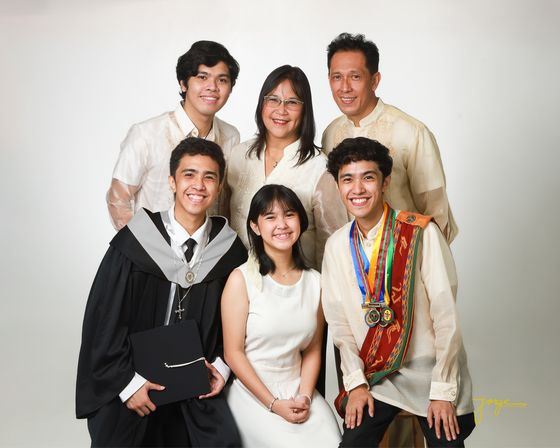 An extended family in white and cream posed together in the studio