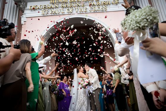Newlyweds kissing under a shower of petals