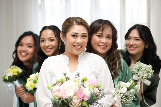 A bride surrounded by her bridesmaids, all holding bouquets
