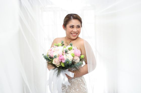 A bride holding her bouquet in soft daylight